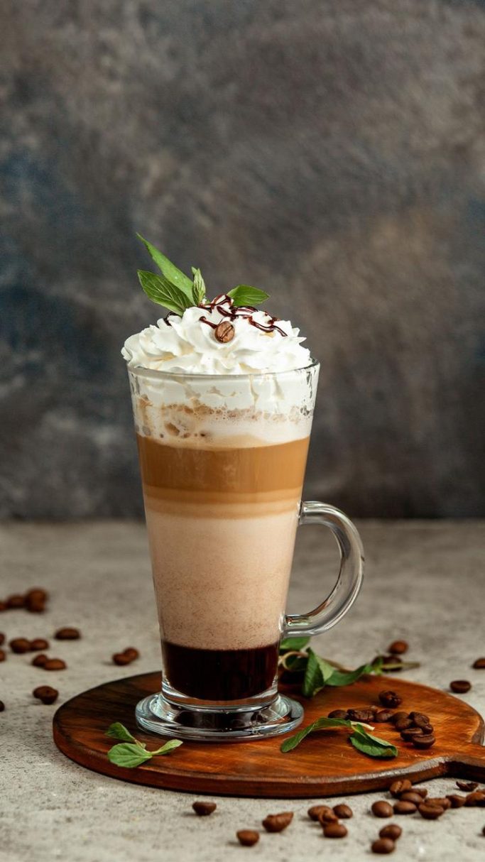 Un verre de café glacé en couches avec crème fouettée et chocolat.
